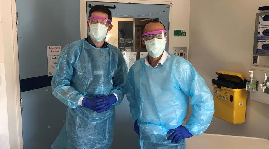 Associate Professor Justin Denholm and Associate Professor Steve Tong wearing PPE in a hospital ward