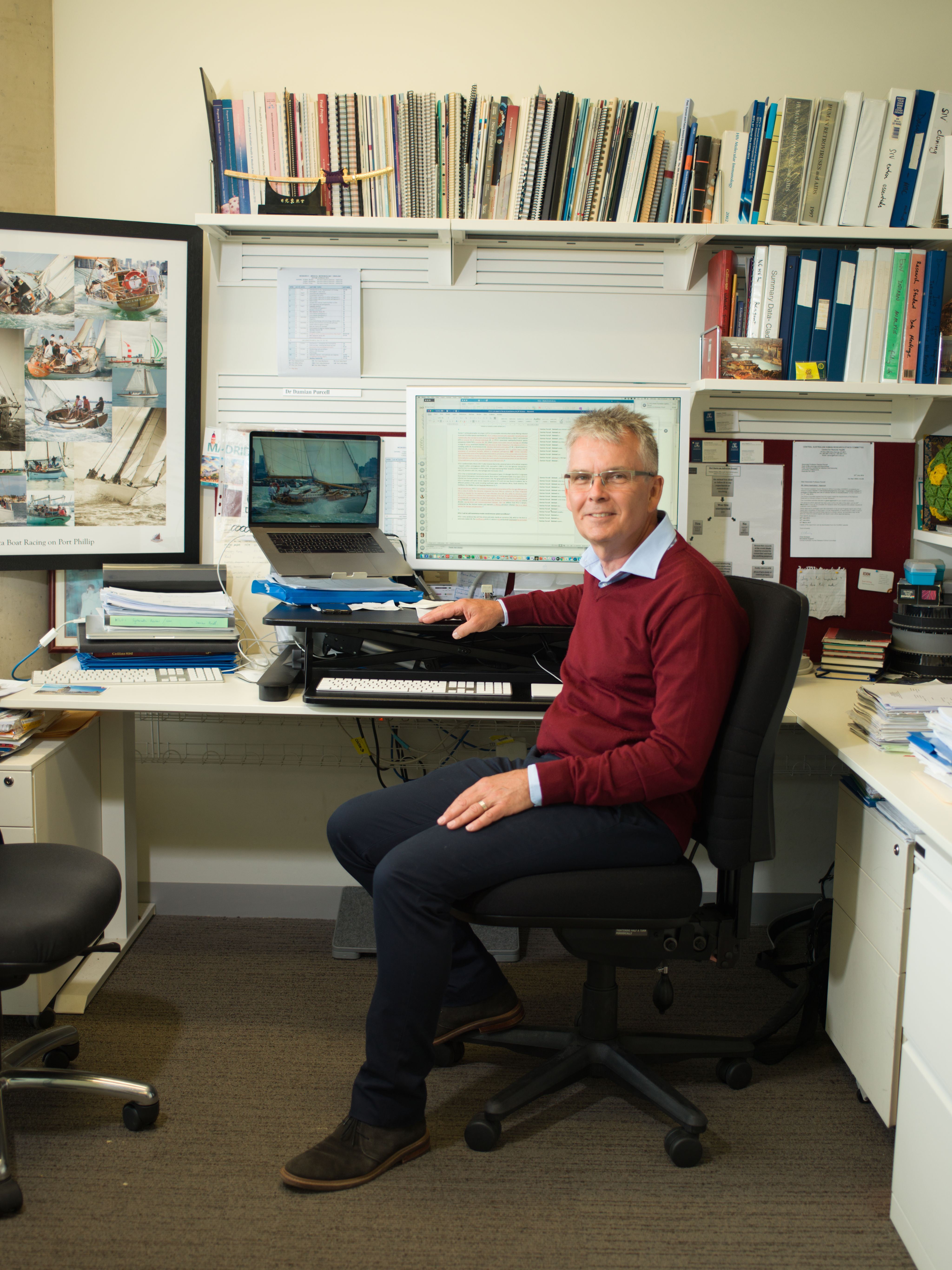 Man sits in office in front of computer