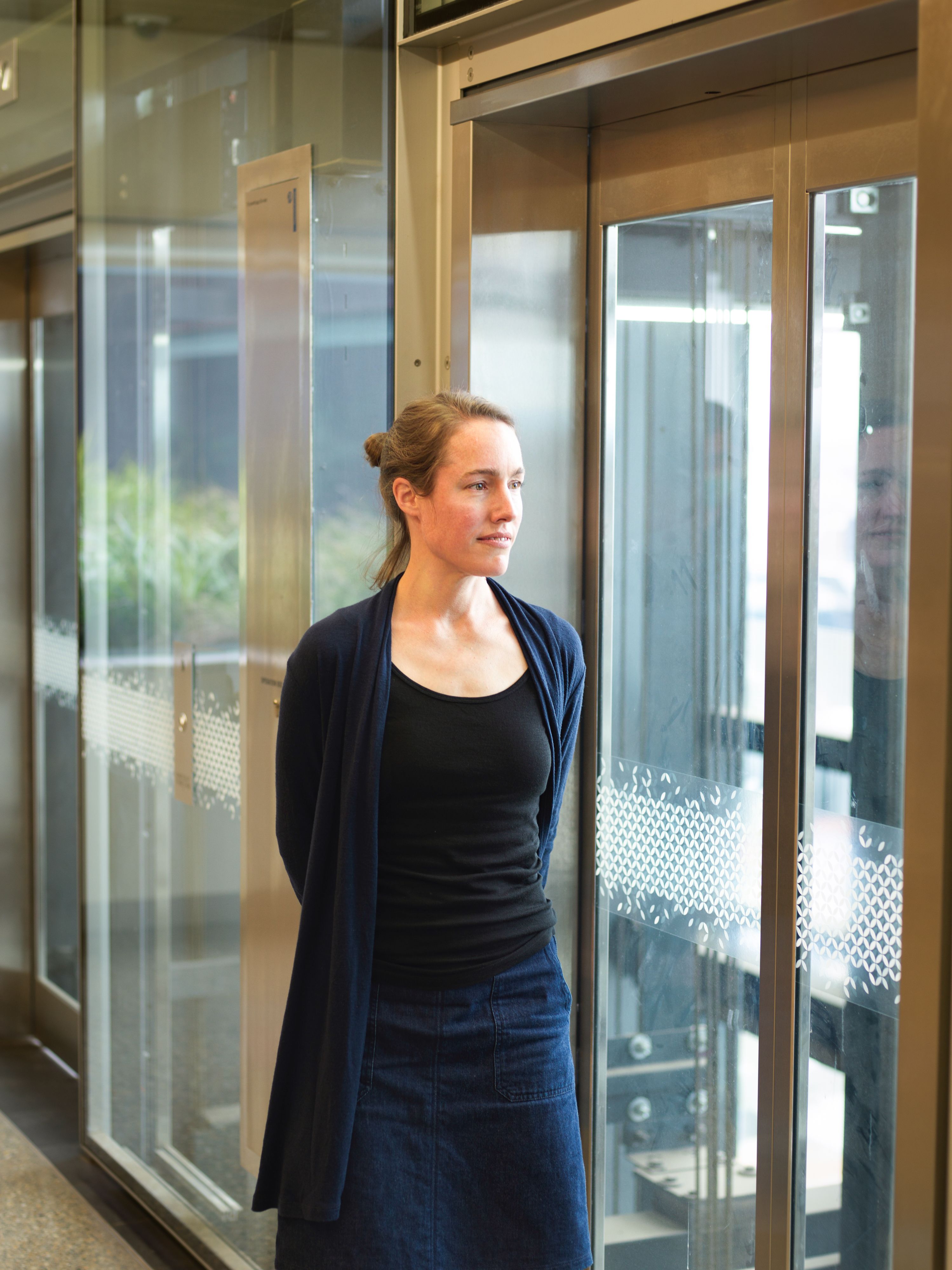 Woman stands by window in foyer